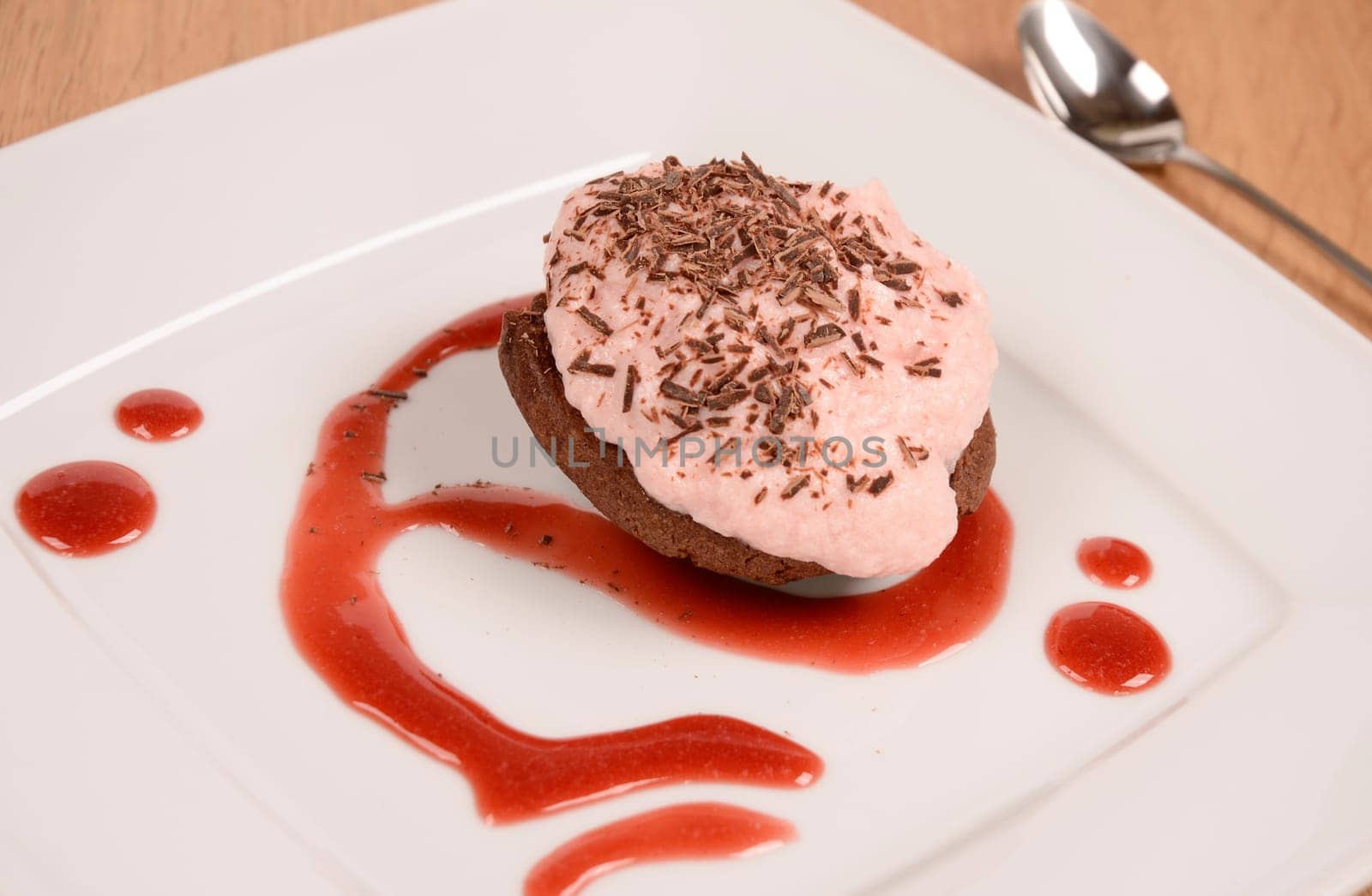 Sweet cake with strawberry cream and chocolate on a plate