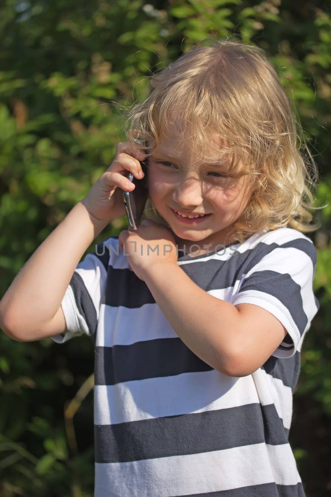 Young blond boy is calling and smiling