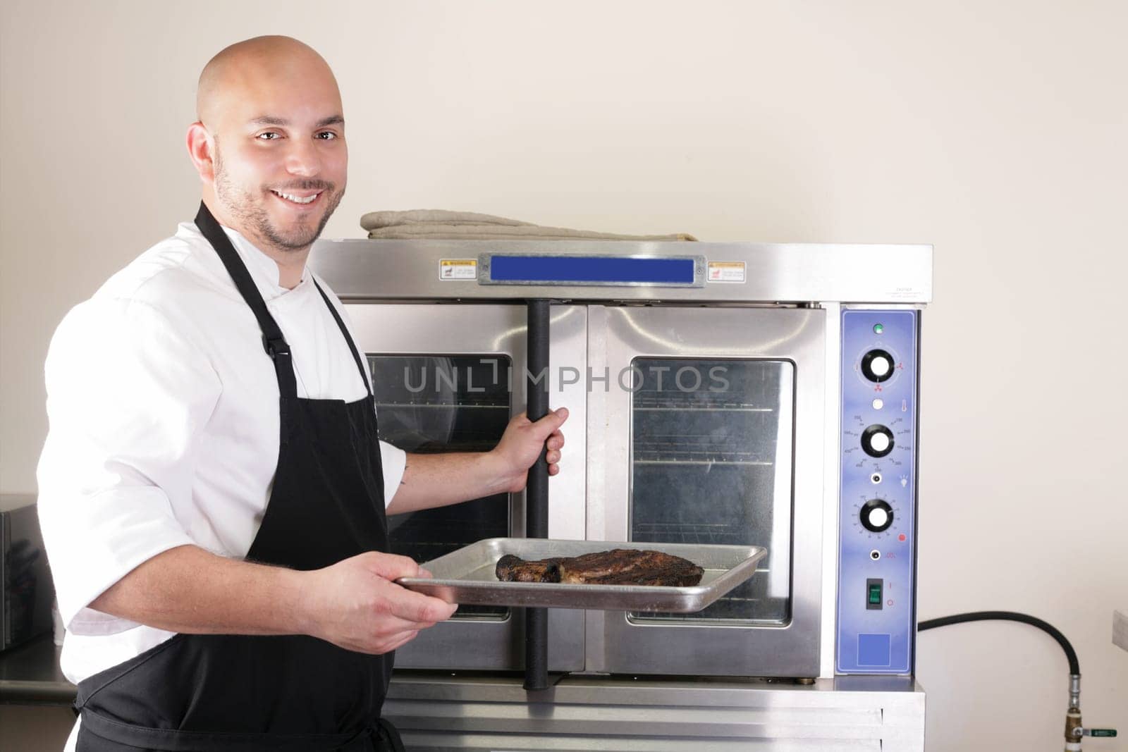 Happy chef taking his freshly baked rib-eye steak