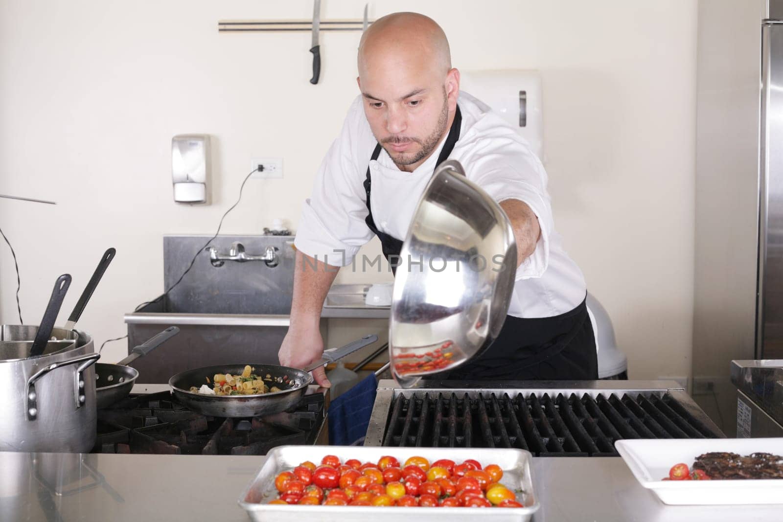 Chef in kitchen cooking, he is working on the sauce for the food