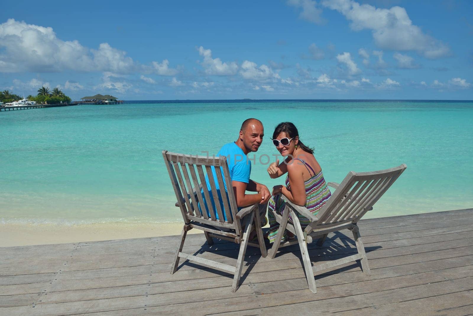 happy young couple have fun and relax at summer vacation on background maldives travel location and beautiful white sand beach