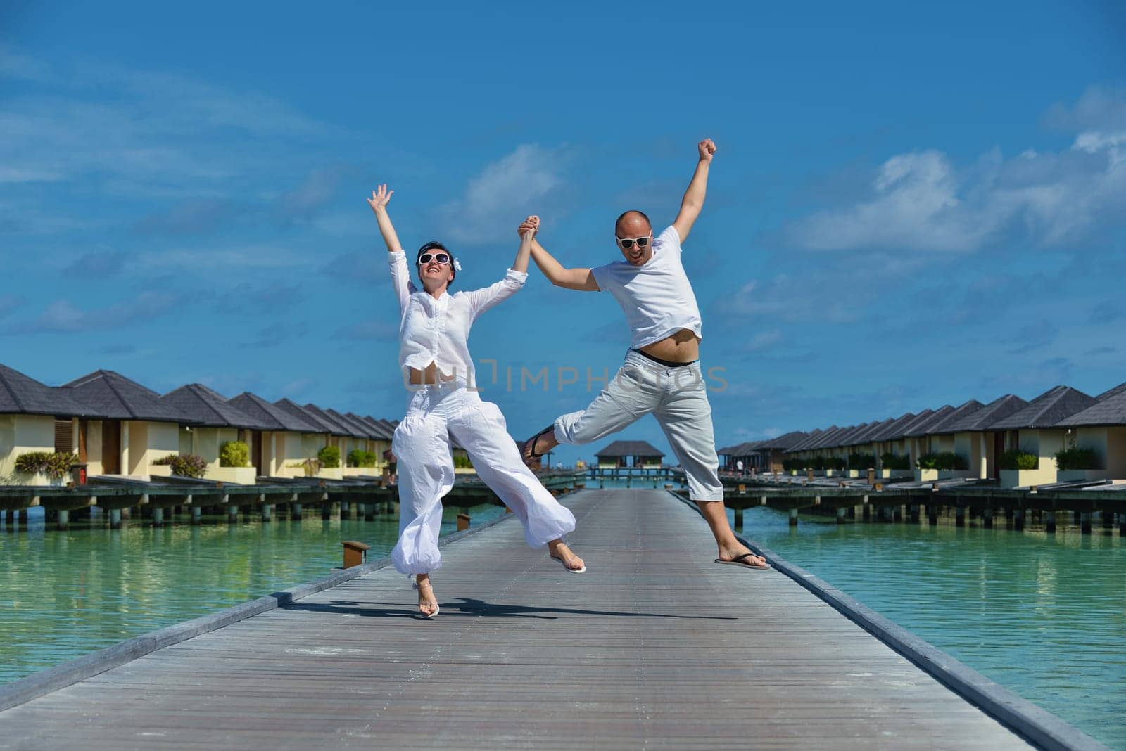 happy young couple have fun and relax at summer vacation on background maldives travel location and beautiful white sand beach