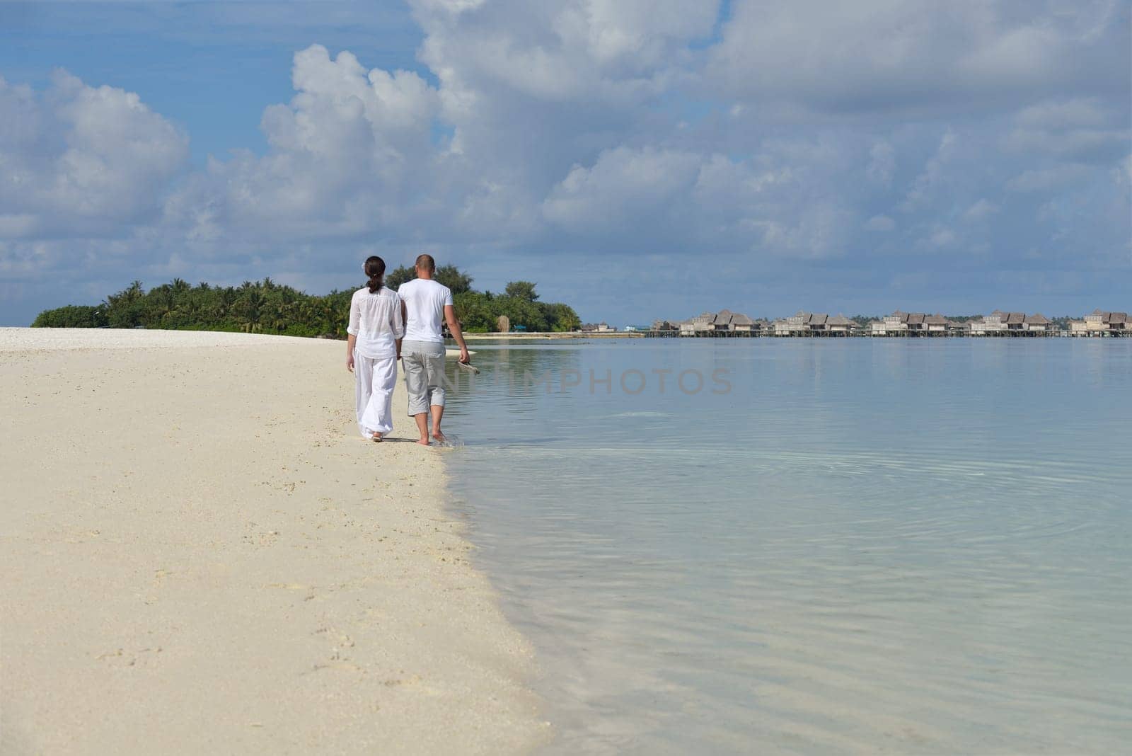 happy young couple have fun and relax at summer vacation on background maldives travel location and beautiful white sand beach