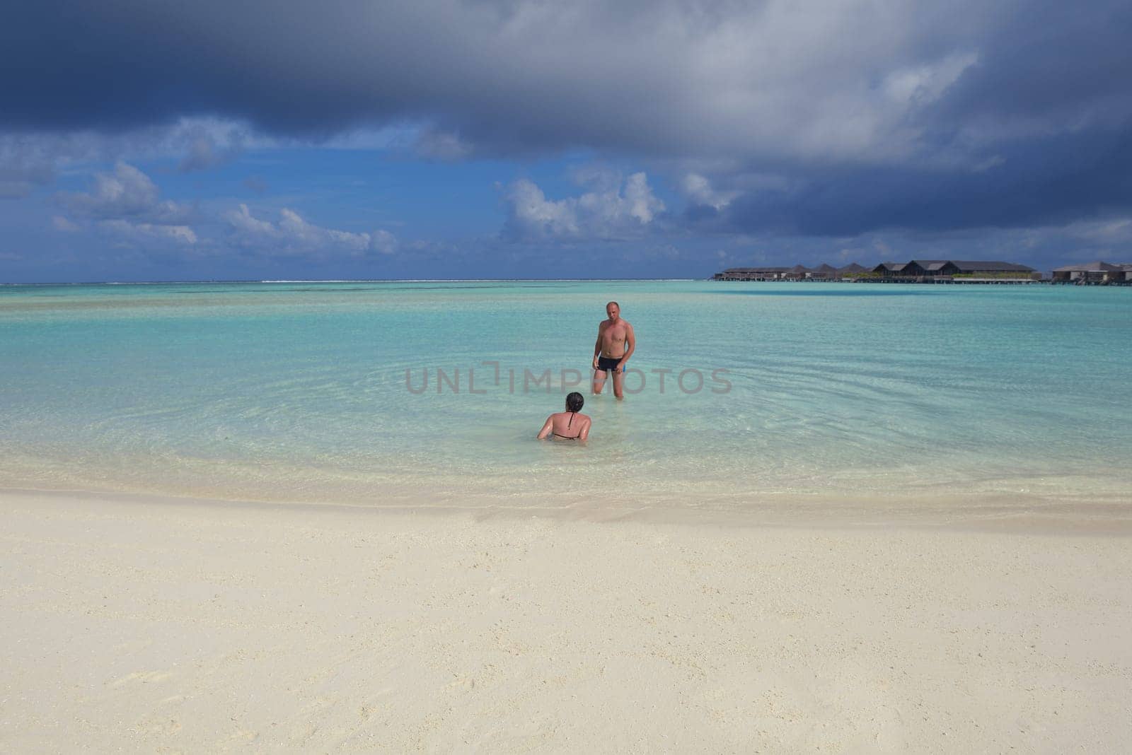 happy young couple have fun and relax at summer vacation on background maldives travel location and beautiful white sand beach
