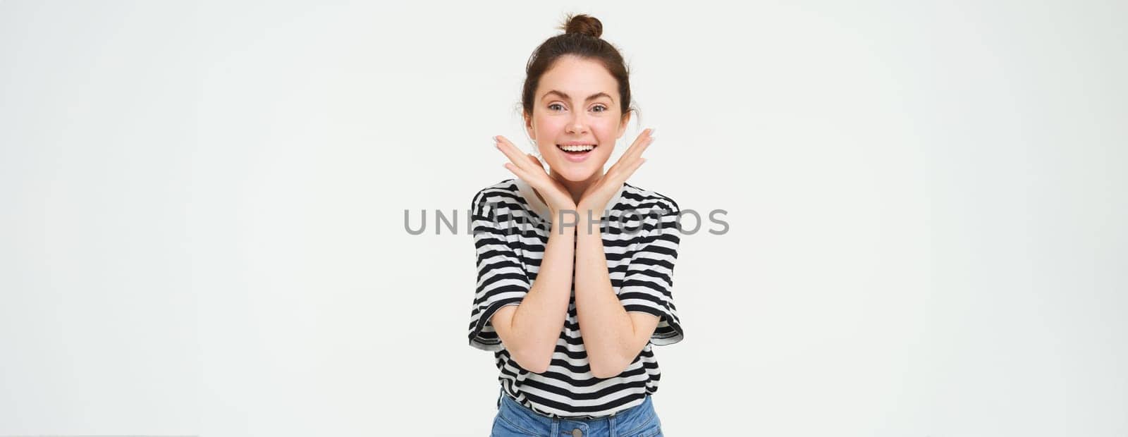 Portrait of beautiful, excited brunette woman, feeling excited and upbeat, smiling and looking happy, standing over white background.