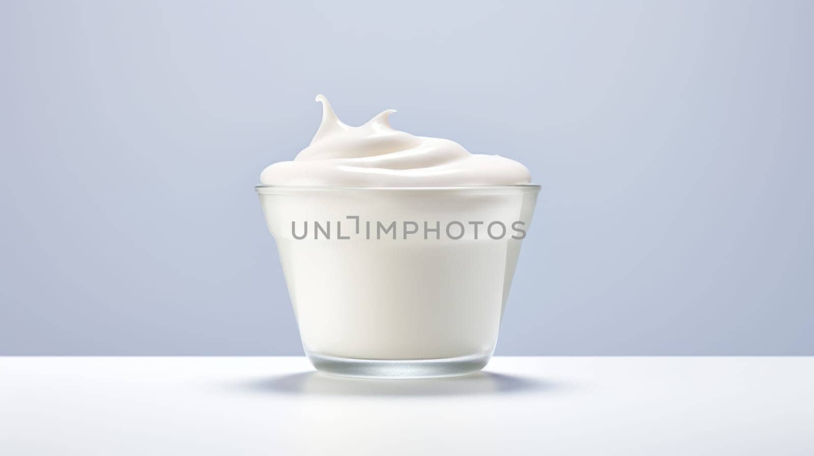 A glass of milk with whipped cream on a blue background