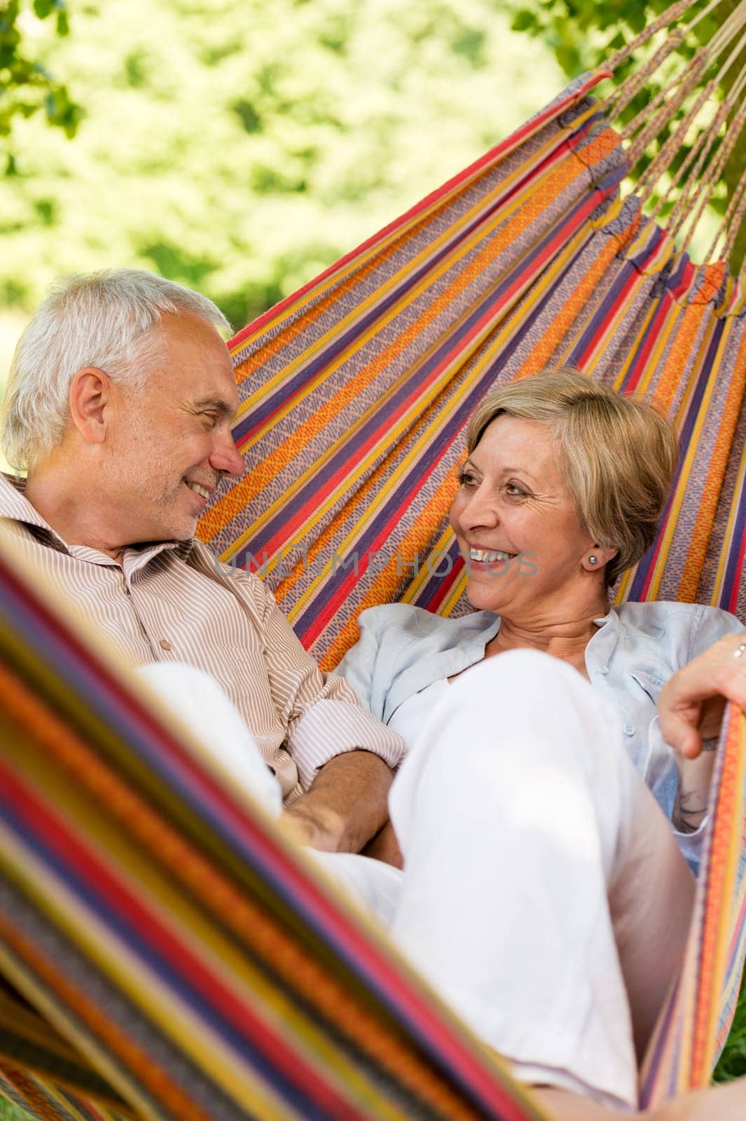 Happy elderly couple lying in hammock