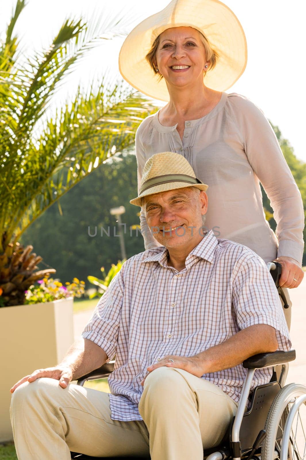 Happy senior wife with husband in wheelchair retirement
