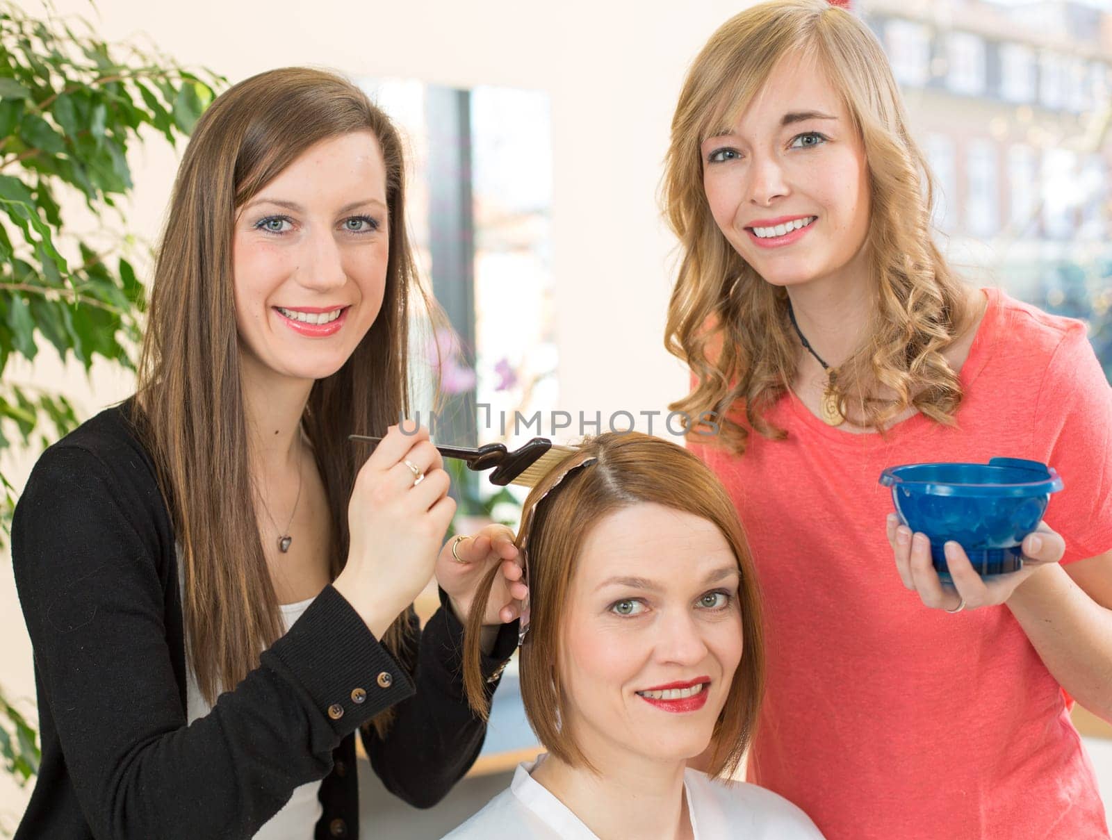hairstylists or hairdresser dying hair of customer with color paint