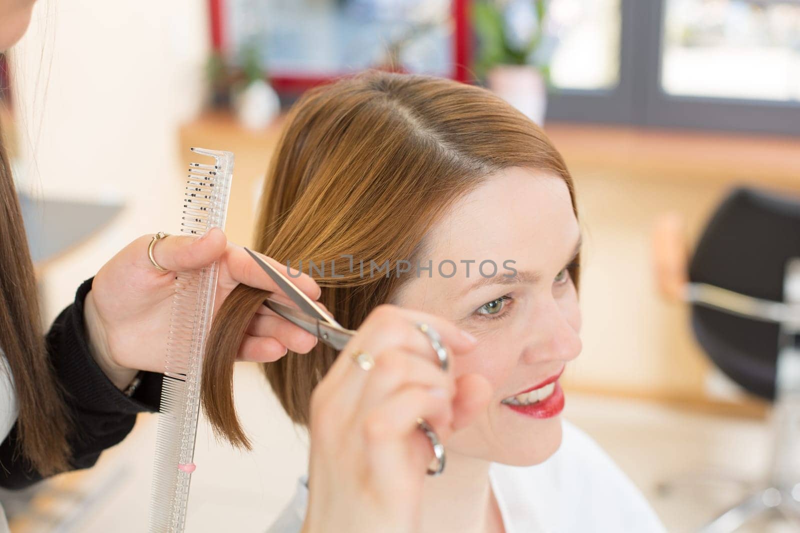 Hairdresser cutting hair in salon closeup