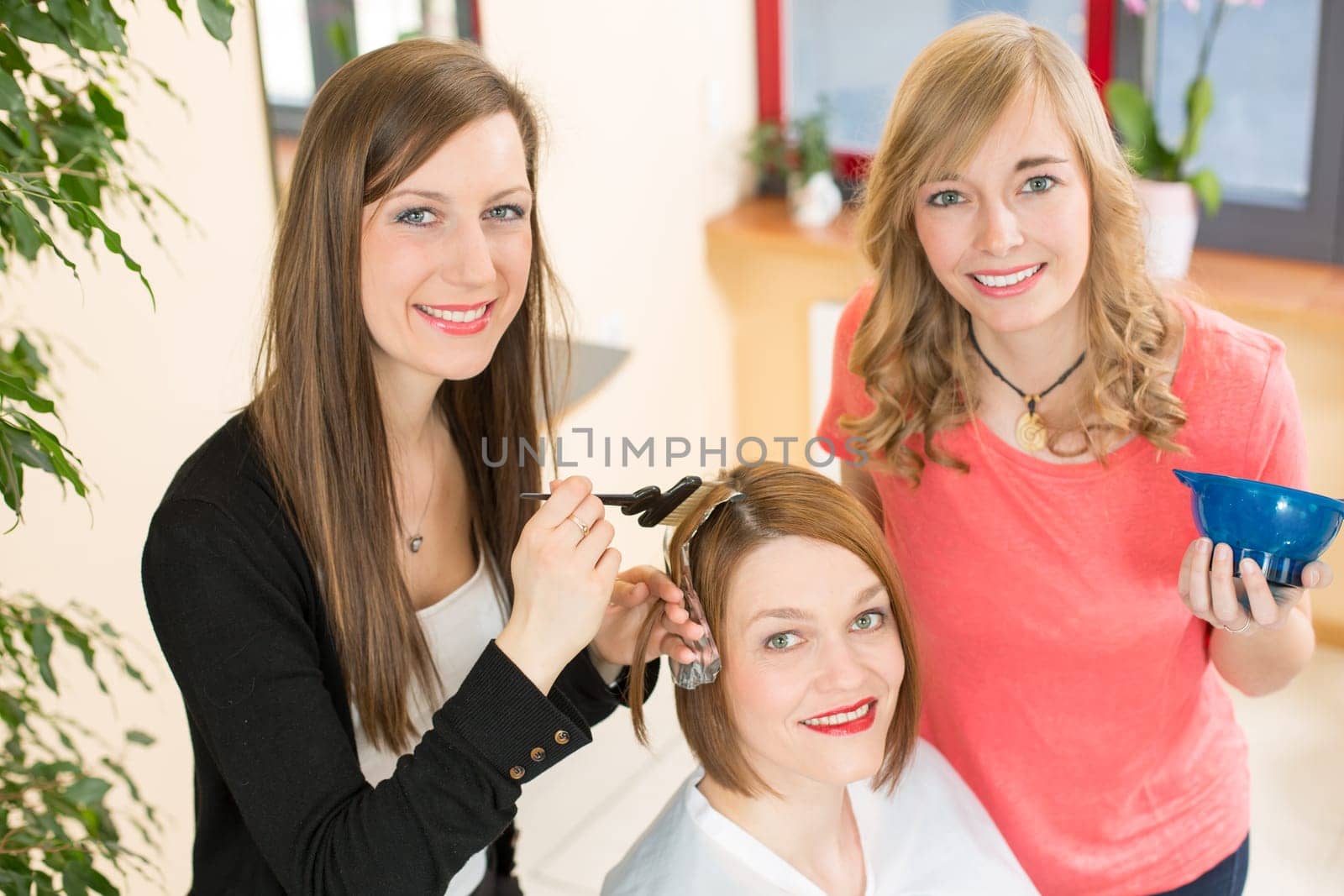 hairstylists or hairdresser dying hair of customer with color paint