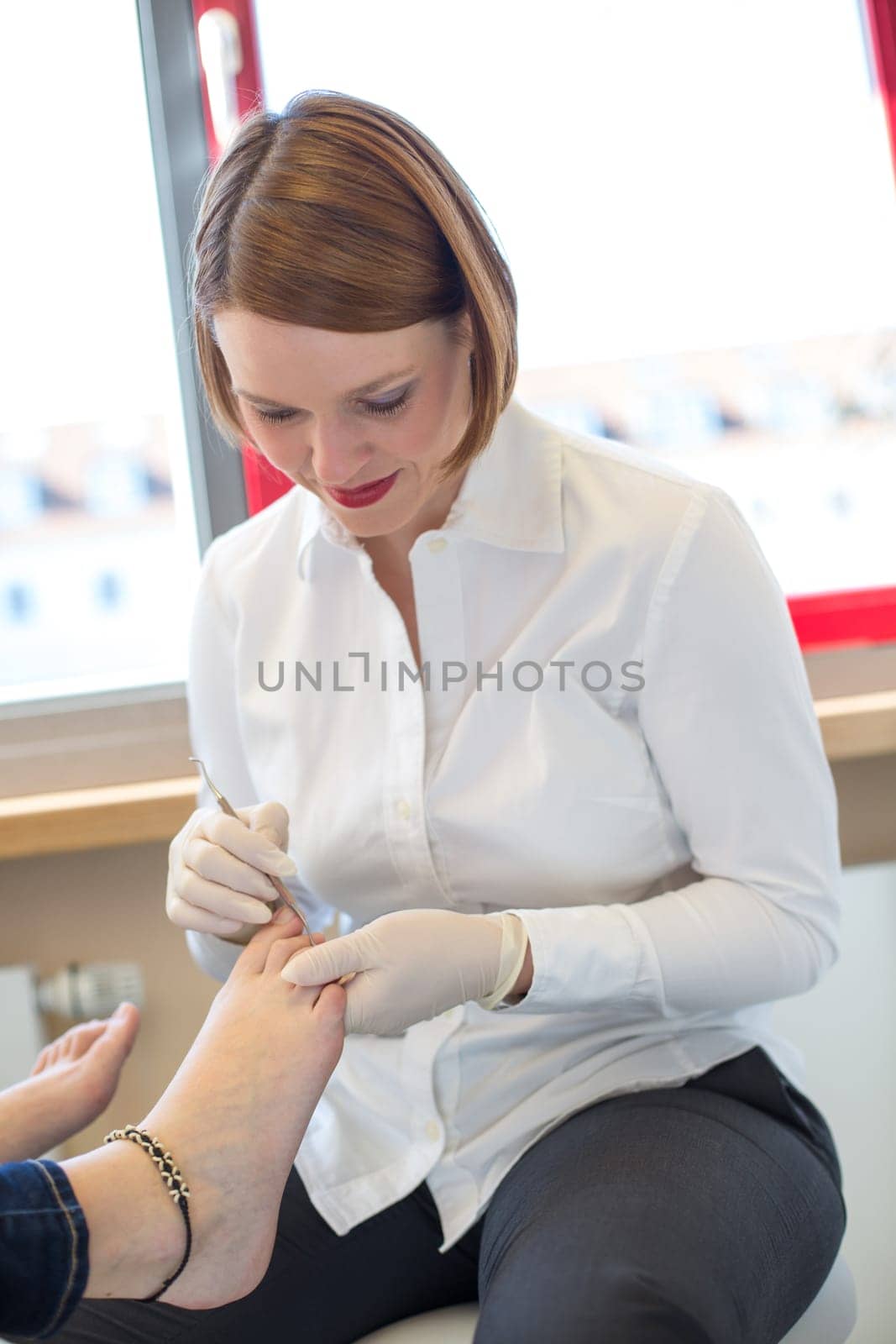 Pedicure at work in salon caring for customers foot nails