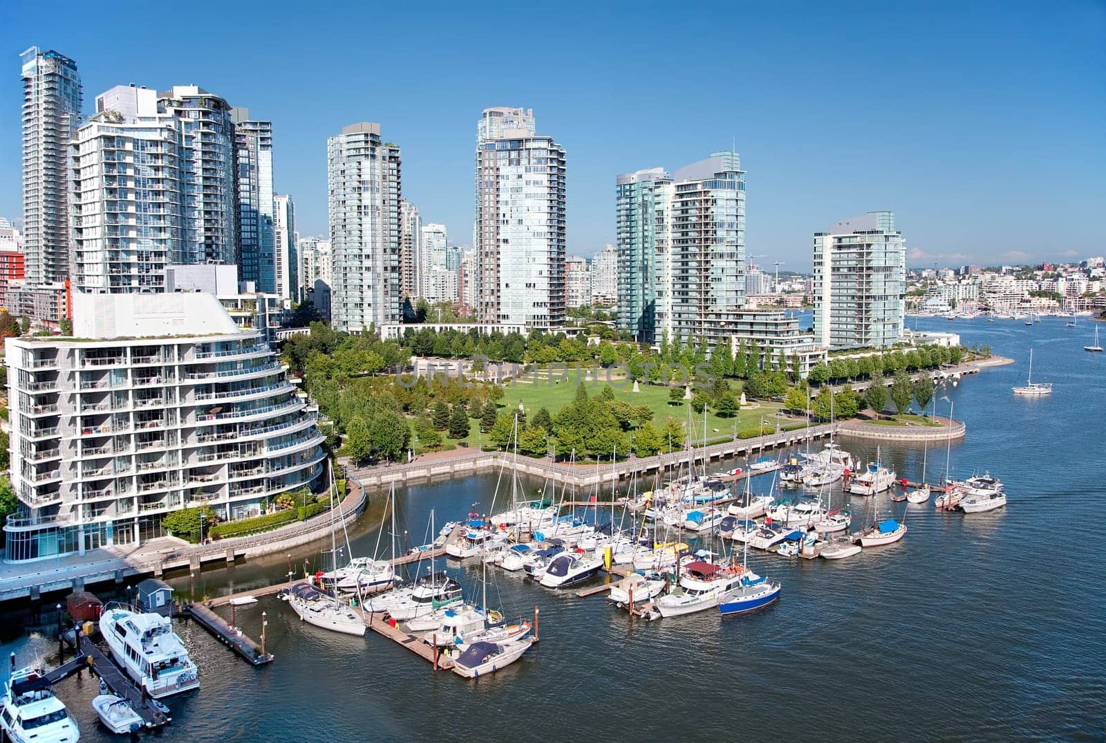 Looking down from the Granville Bridge, this is an east view of False Creek, a short inlet in the heart of Vancouver, British Columbia, Canada. The green area is George Wainborn park surrounded by tall condo buildings, the seaside bicycle route and the marina. False Creek separates downtown for the rest of the city.