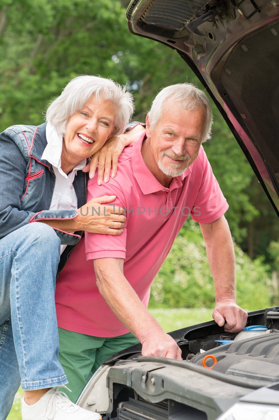 Senior couple at a black car with an open hood