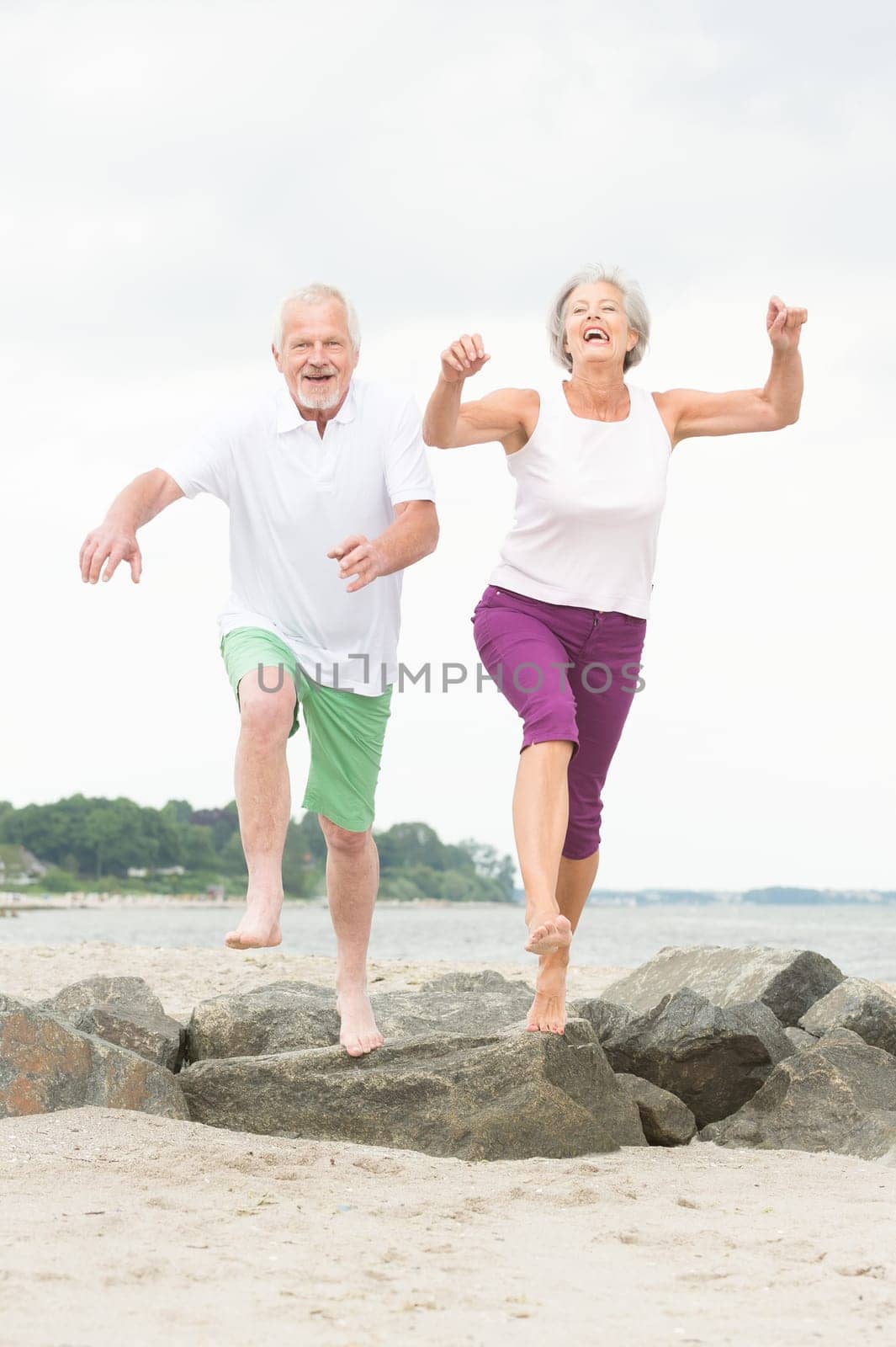 Active senior couple on the beach doing sports