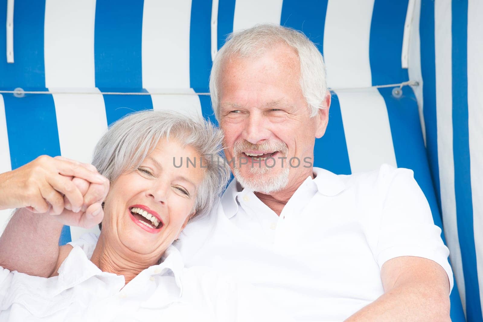 Portrait of a happy senior couple in a beach chair