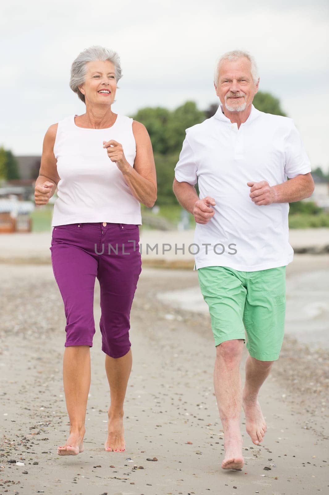 Active senior couple on the beach doing sports