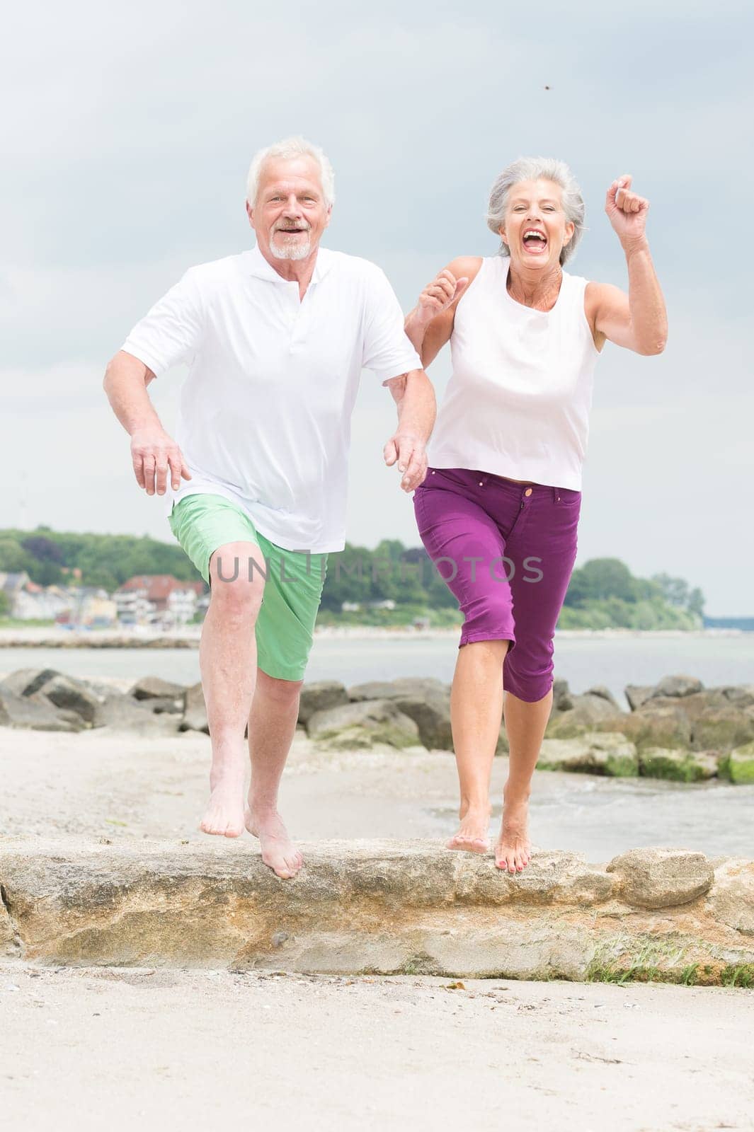 Active senior couple on the beach doing sports