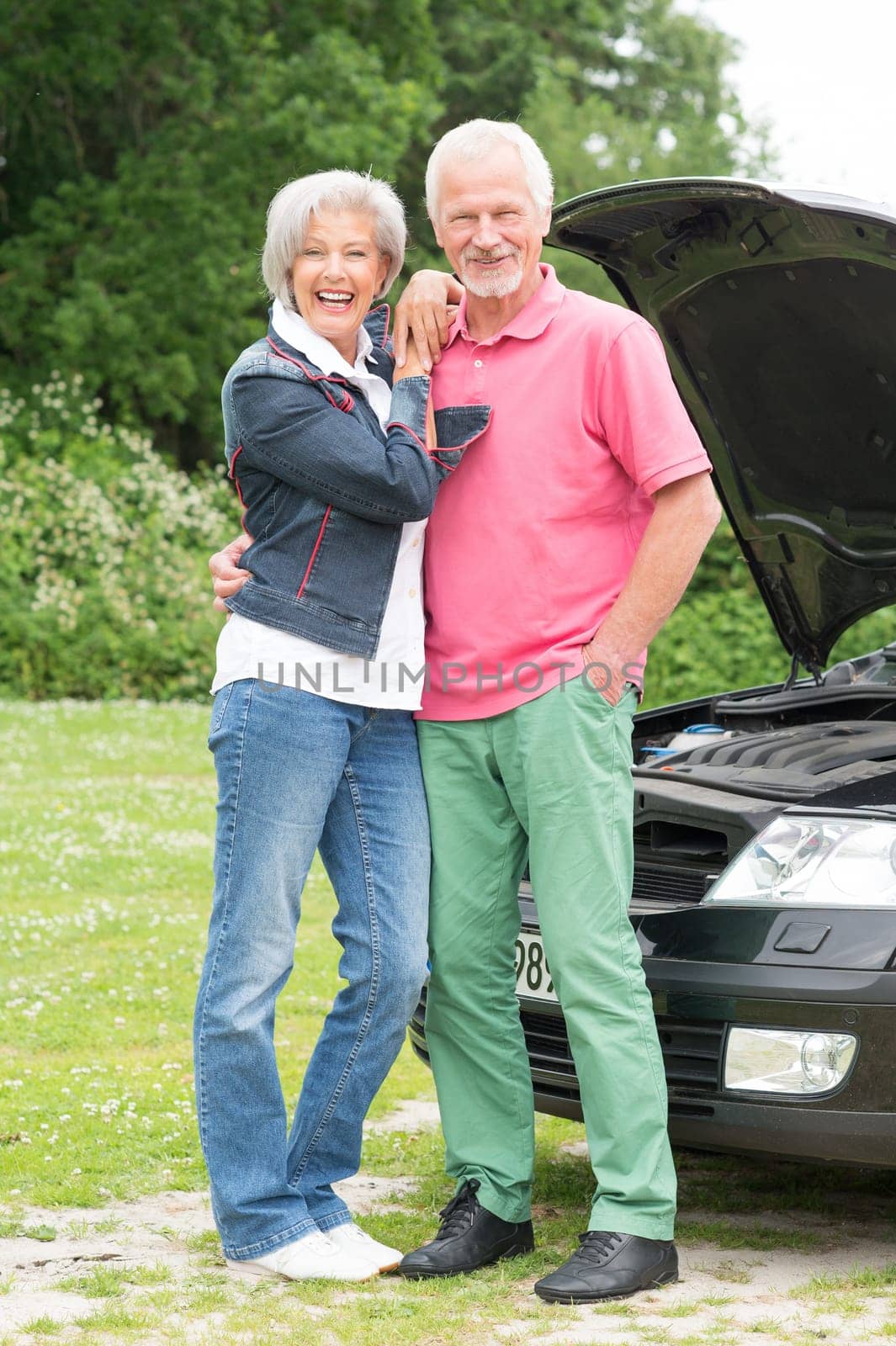 Senior couple at a black car with an open hood