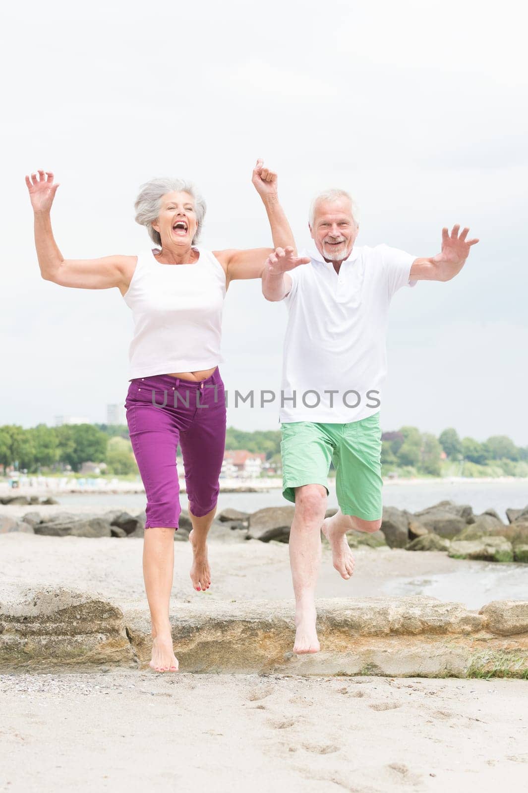 Active senior couple on the beach doing sports