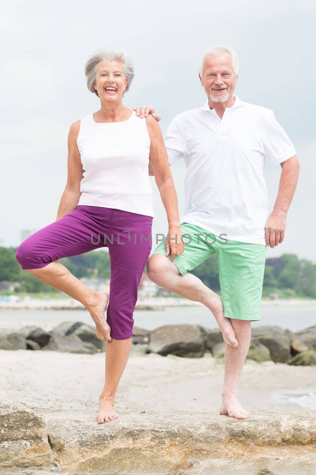 Active senior couple on the beach doing sports
