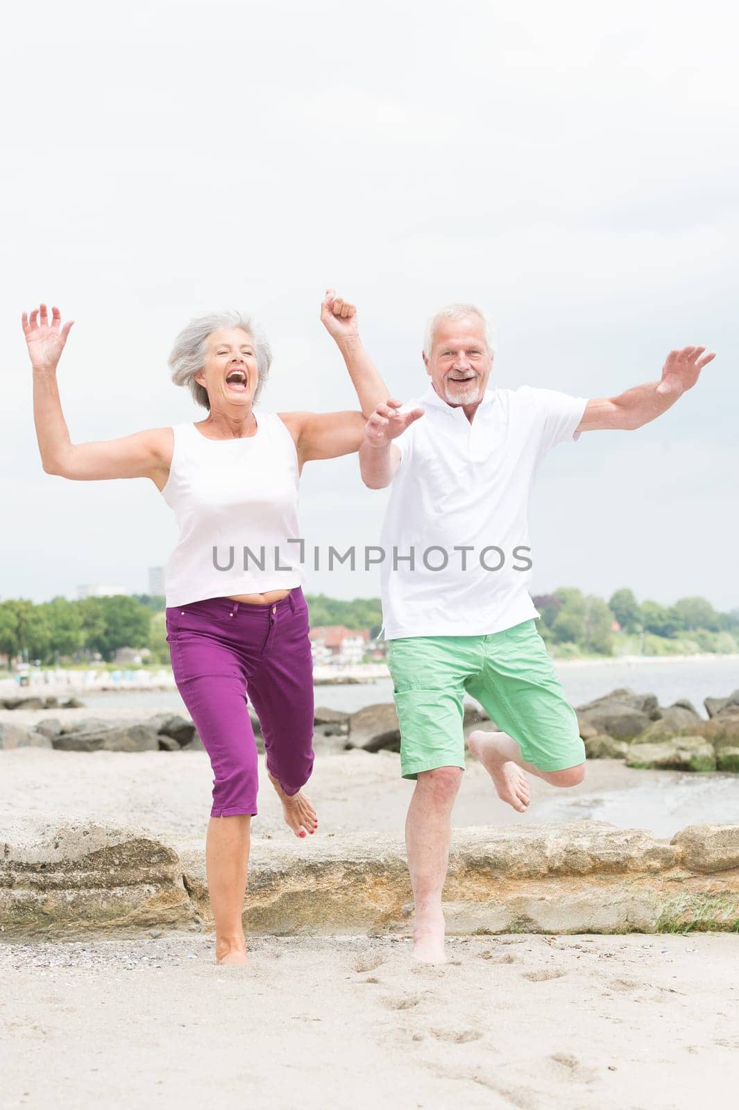 Active senior couple on the beach doing sports