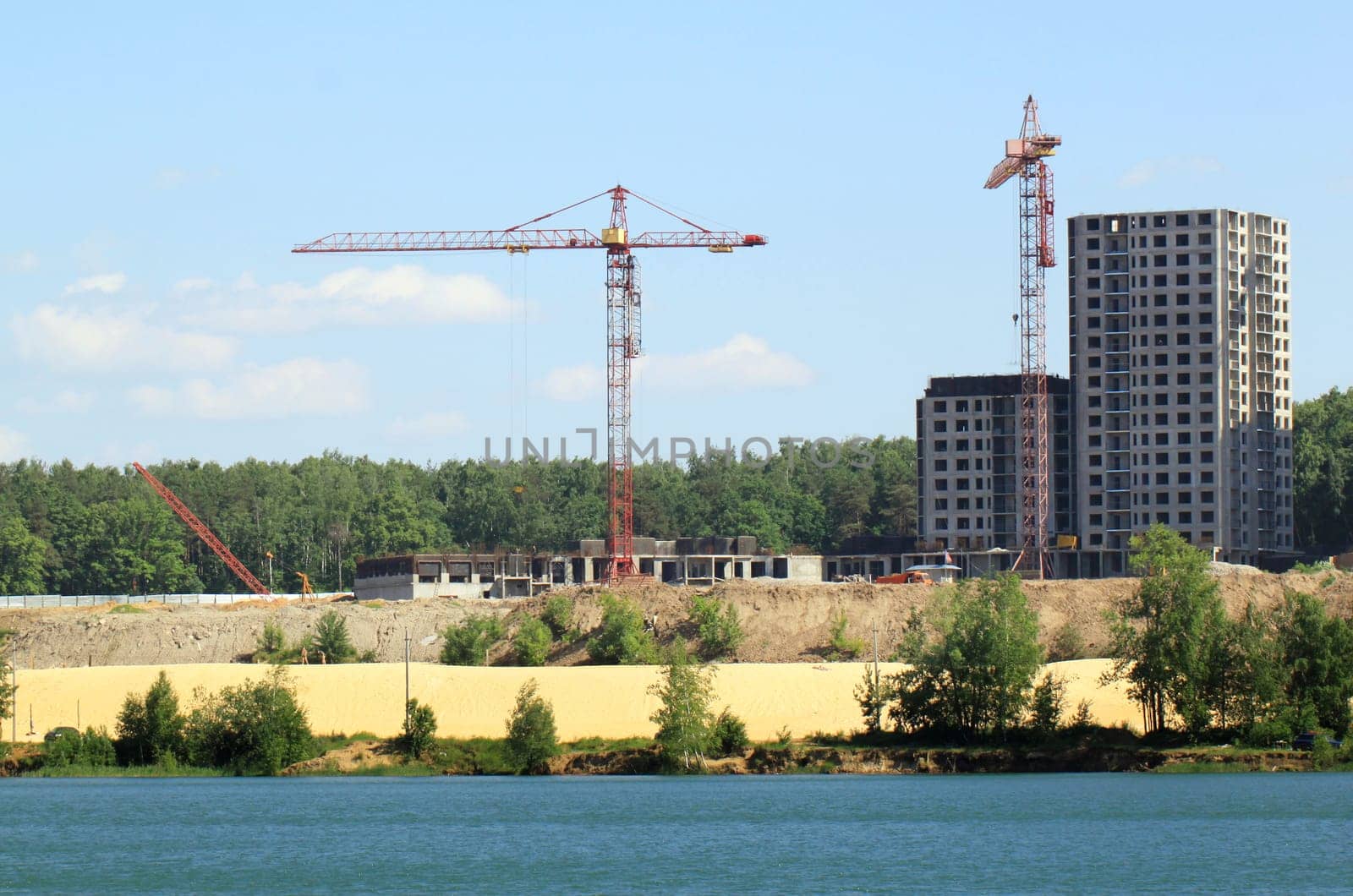 Building crane and building under construction against blue sky