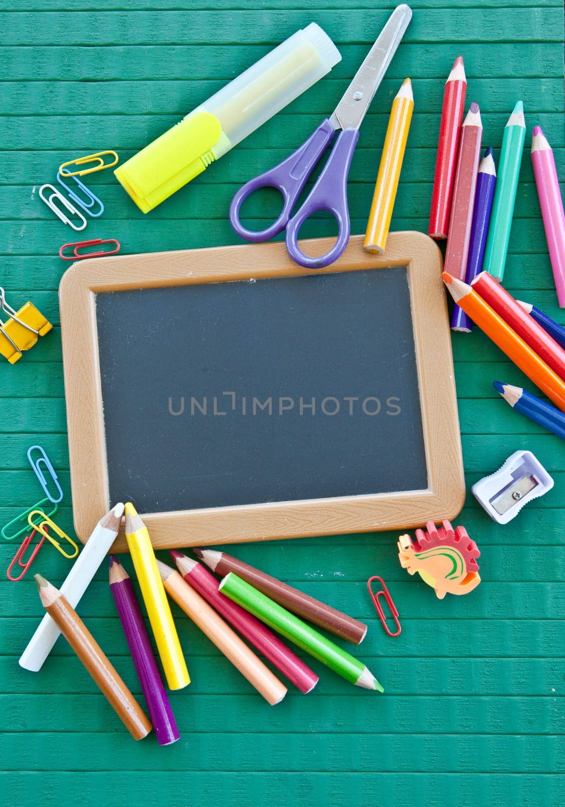 Small blackboard with free text space with colorful office utensils