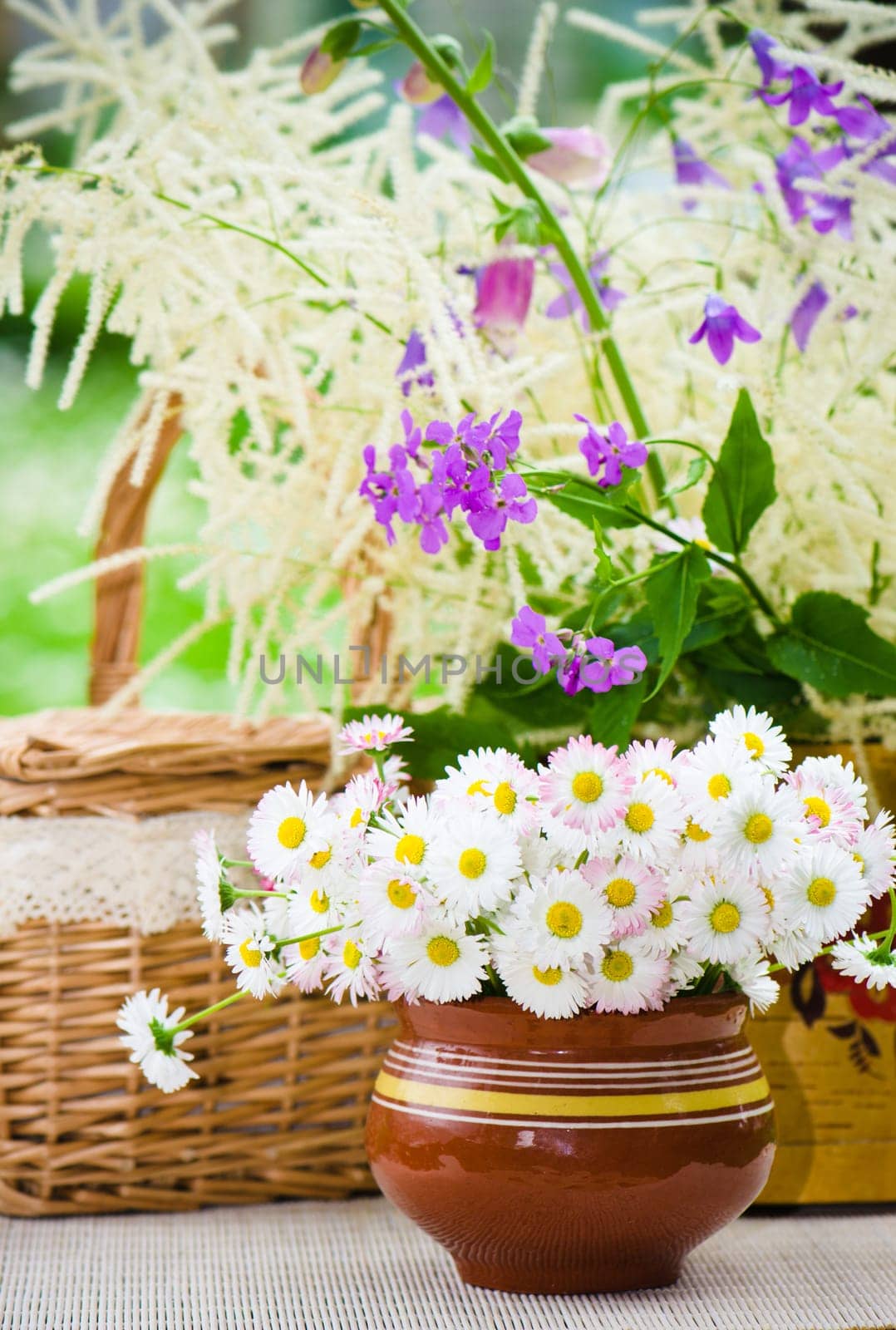 Bouquet of wild flowers in a pot at the table