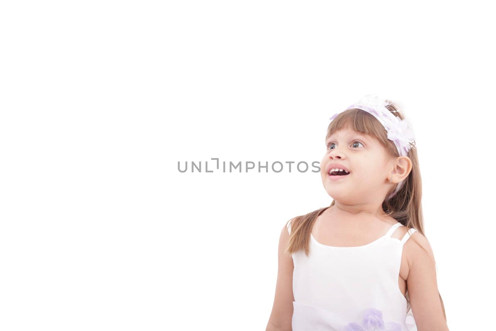 cute little girl very surprised and looking up somewhere against white background