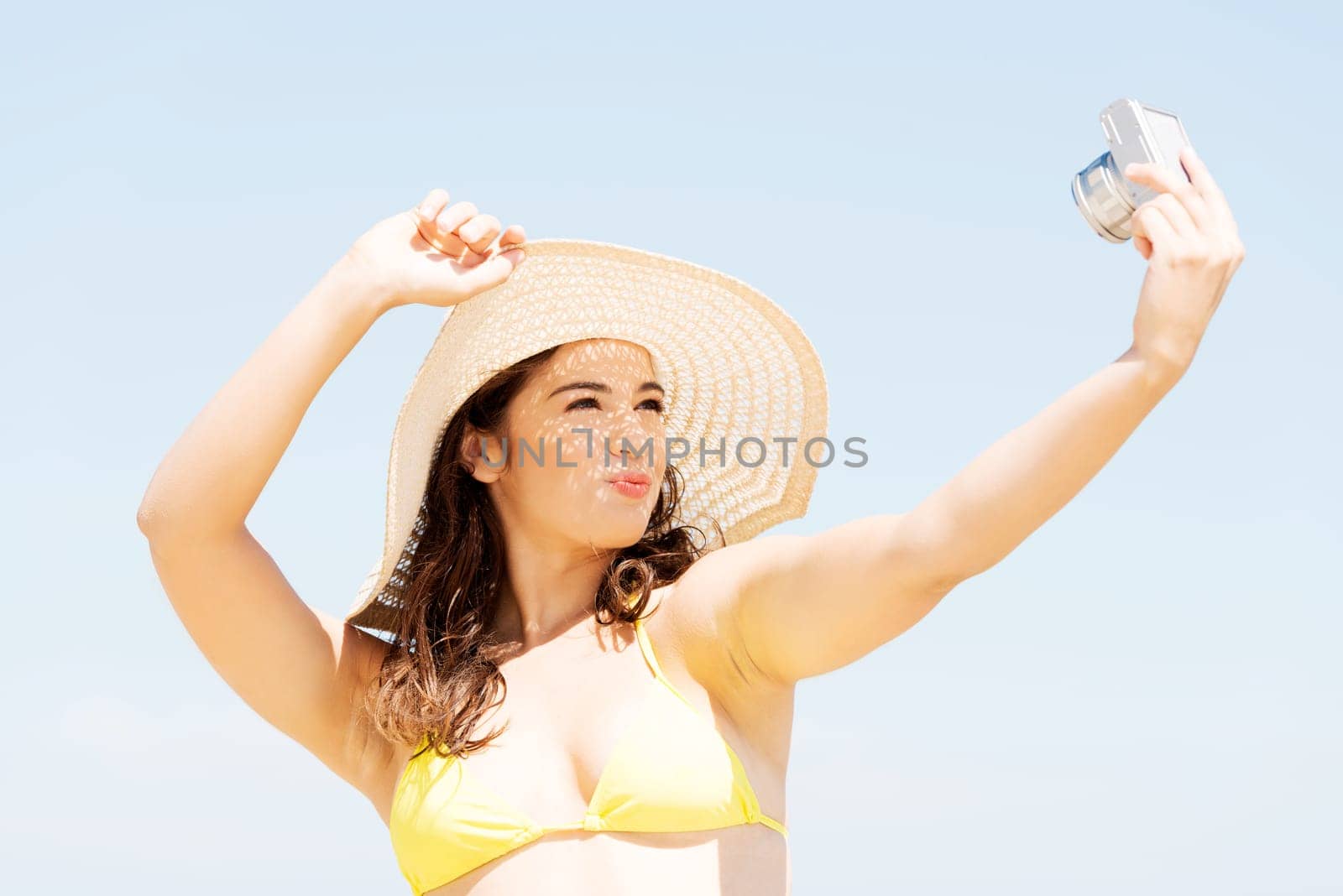 attractive cheerful summer woman talking pictures with digital camera.