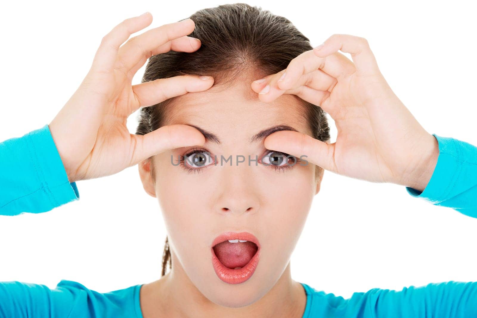 young shocked woman checking her first wrinkles on forehead