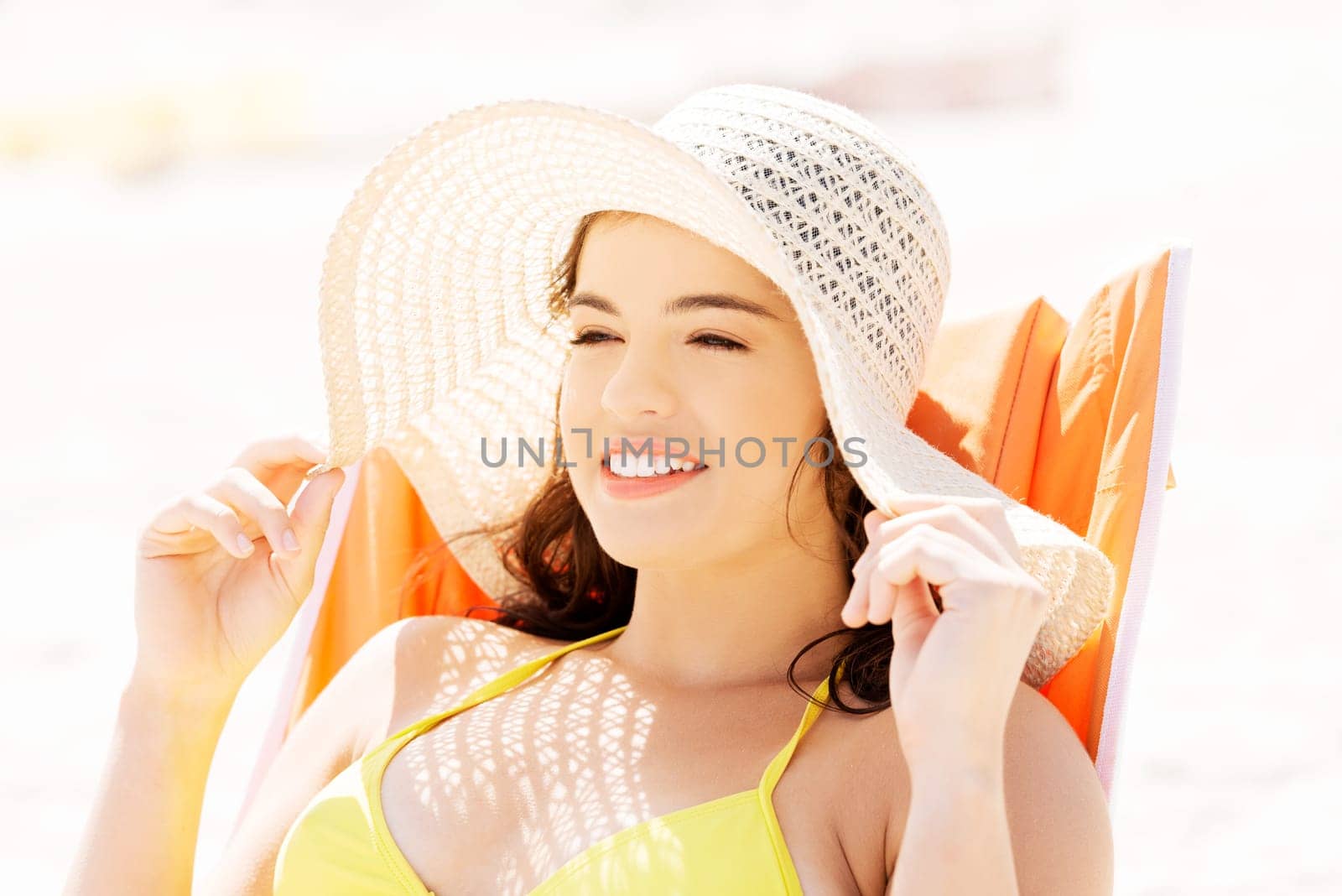 Woman sunbathing and relaxing on beach chair.