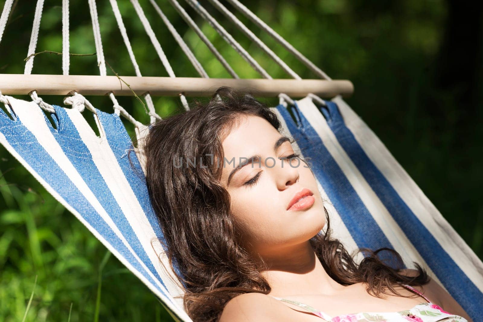 Young woman sleeping in a hammock in garden