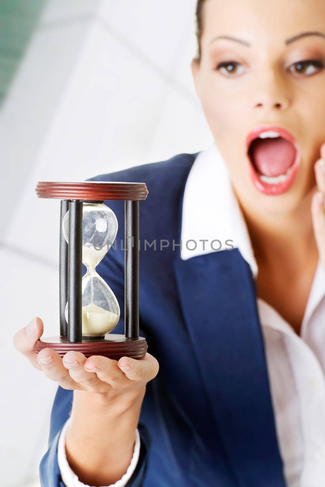 young shocked business woman with hourglass - time concept