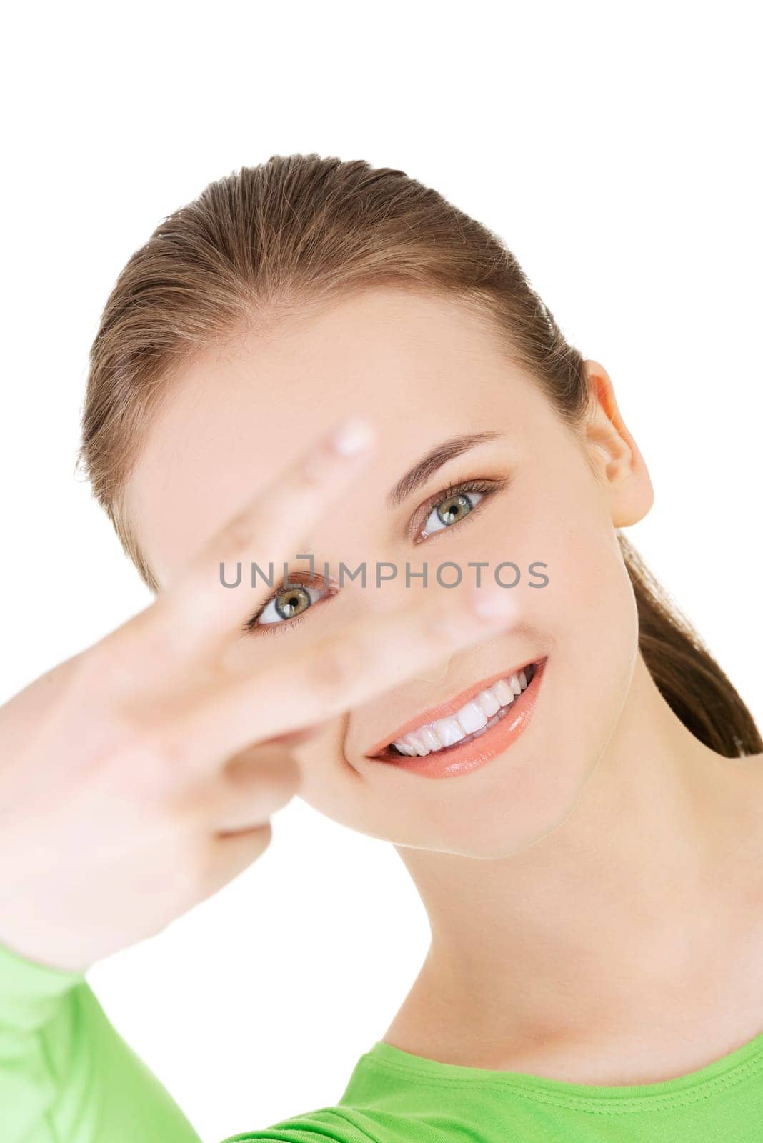 Happy young teen girl showing victory sign isolated on white background