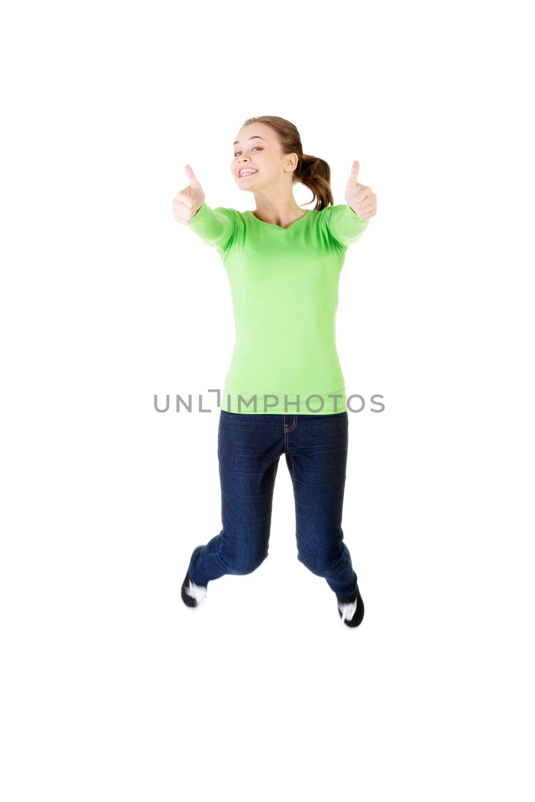 young happy caucasian woman jumping in the air with thumbs up,isolated on white background
