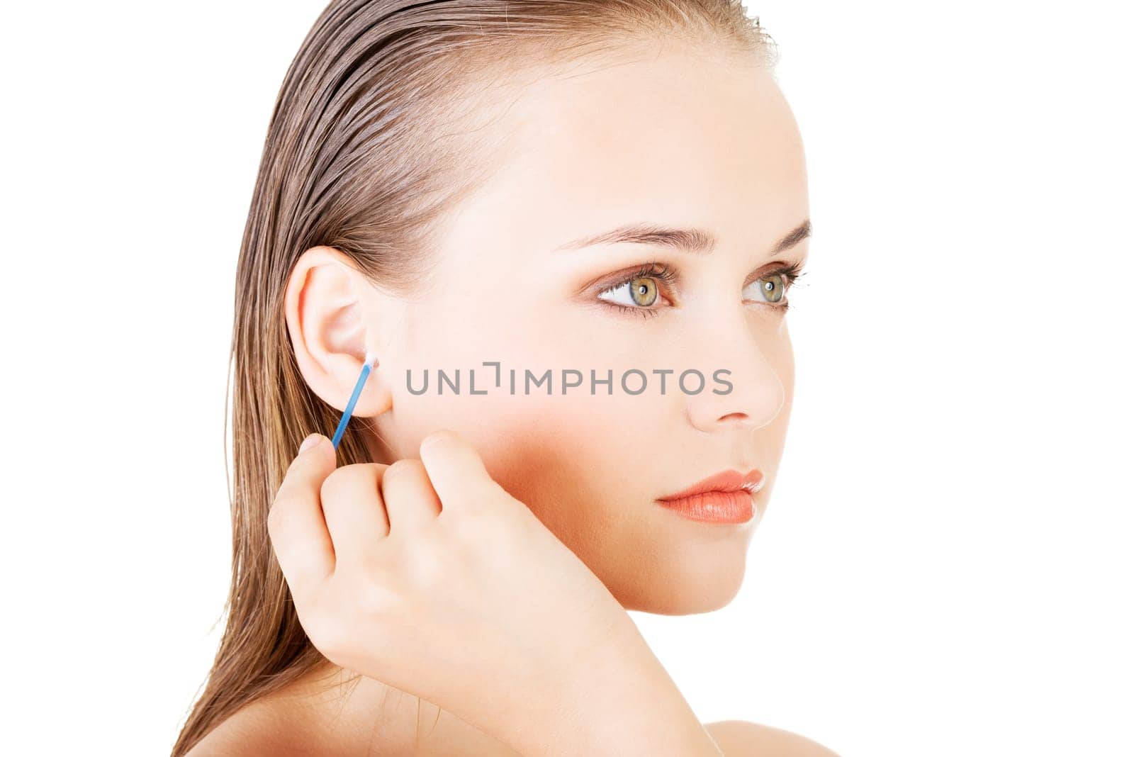 Woman face closeup while cleaning up an ear with a swab,over white.