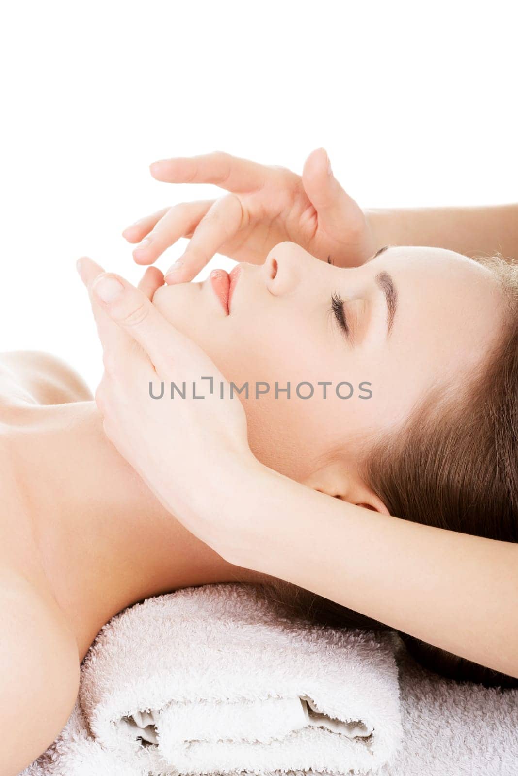 beautiful young relaxed woman enjoy receiving face massage at a spa saloon