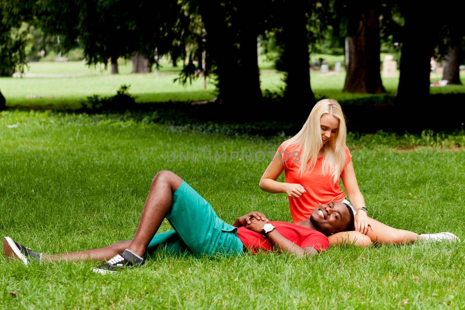 Young in love multicultural couple on a meadow in summer leisure fun