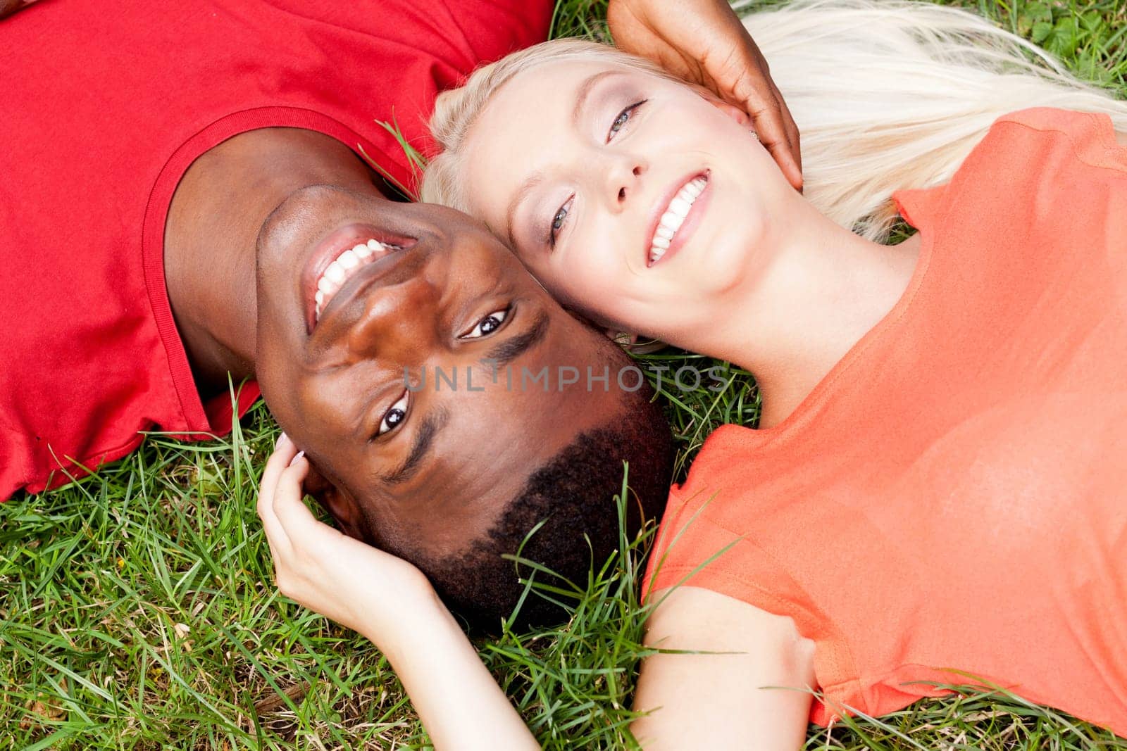 Young in love multicultural couple on a meadow in summer leisure fun