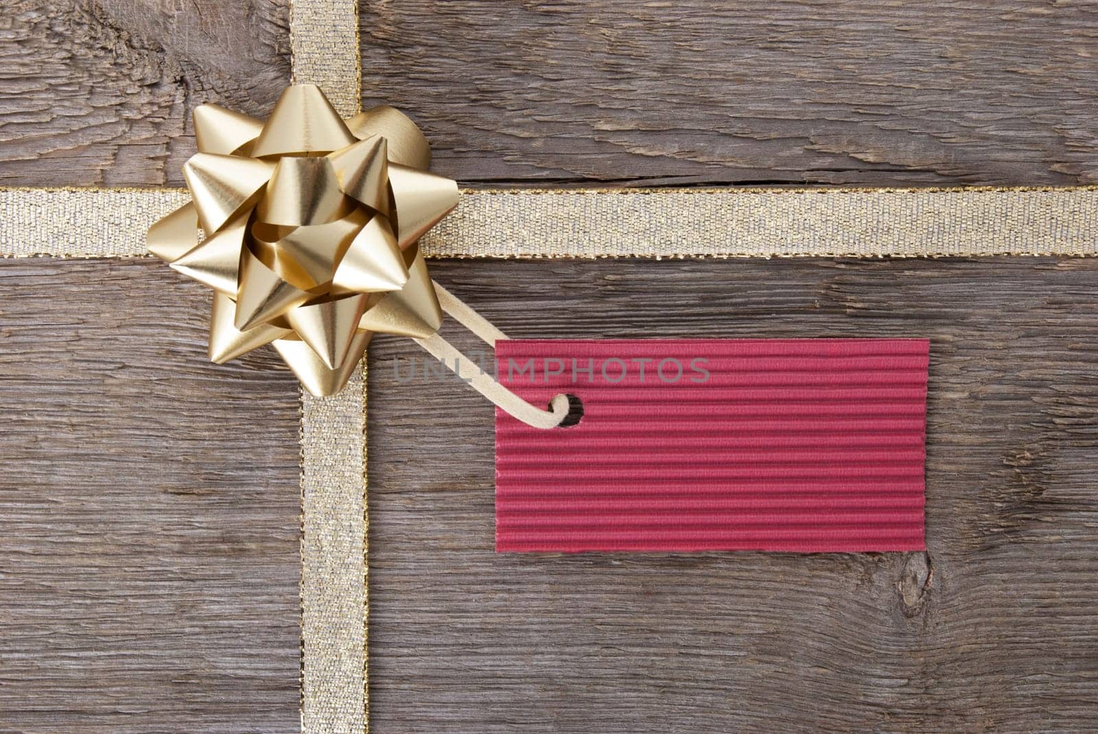 a golden bow with a red label with copy space as background