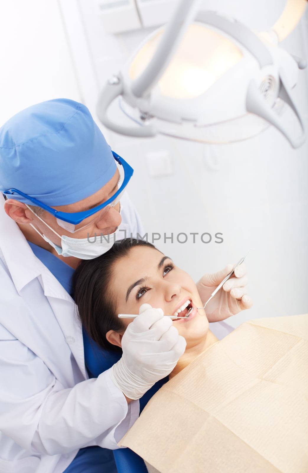 Young girl with open mouth during oral checkup at the dentist’s