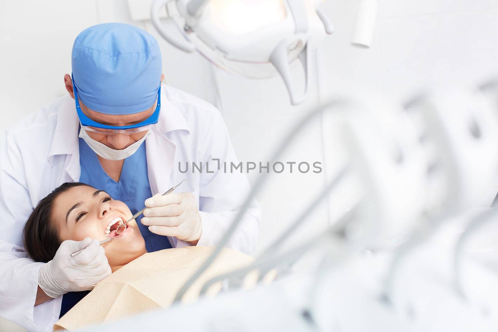 Young girl with open mouth during oral checkup at the dentist’s