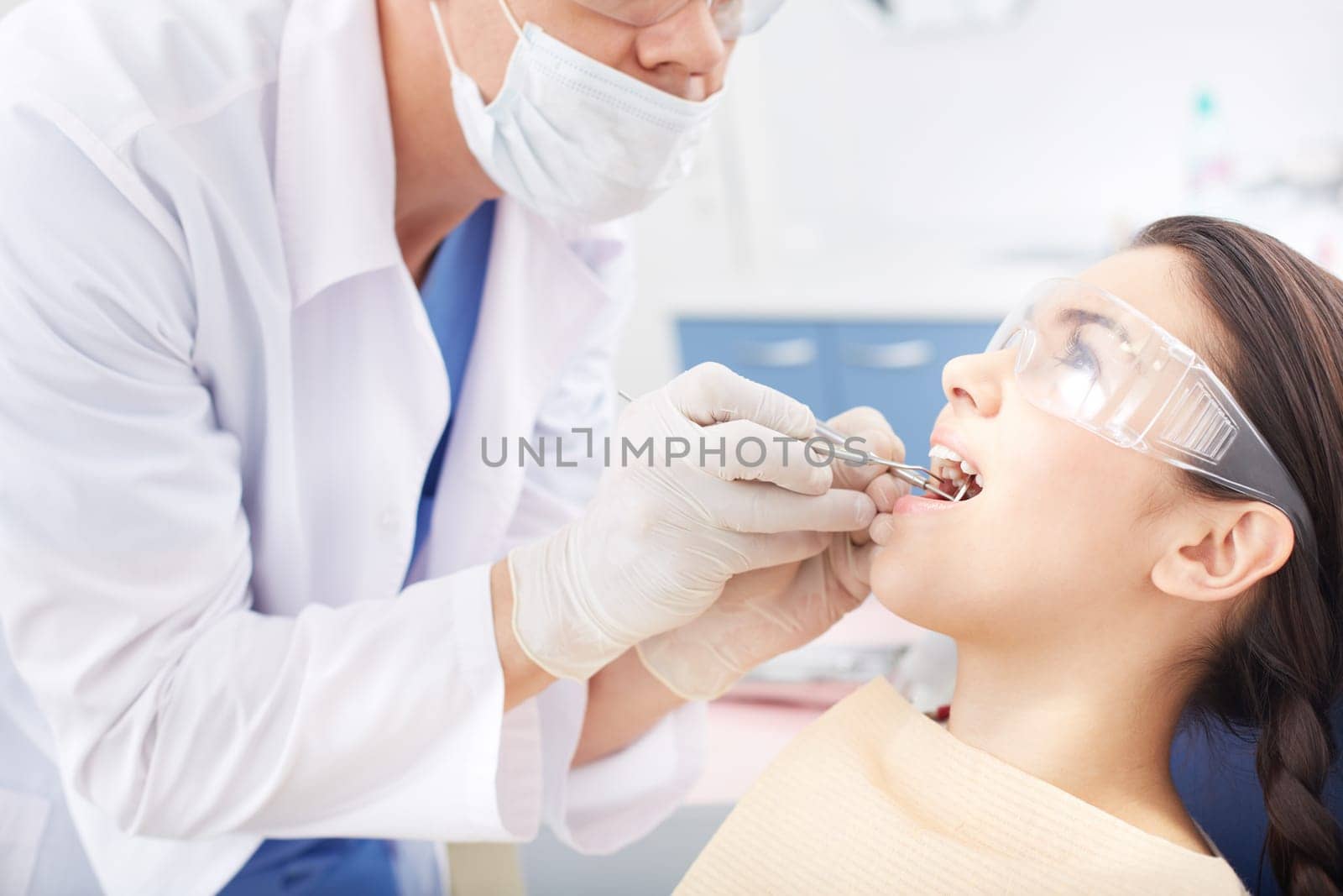 Young girl with open mouth during oral checkup at the dentist’s