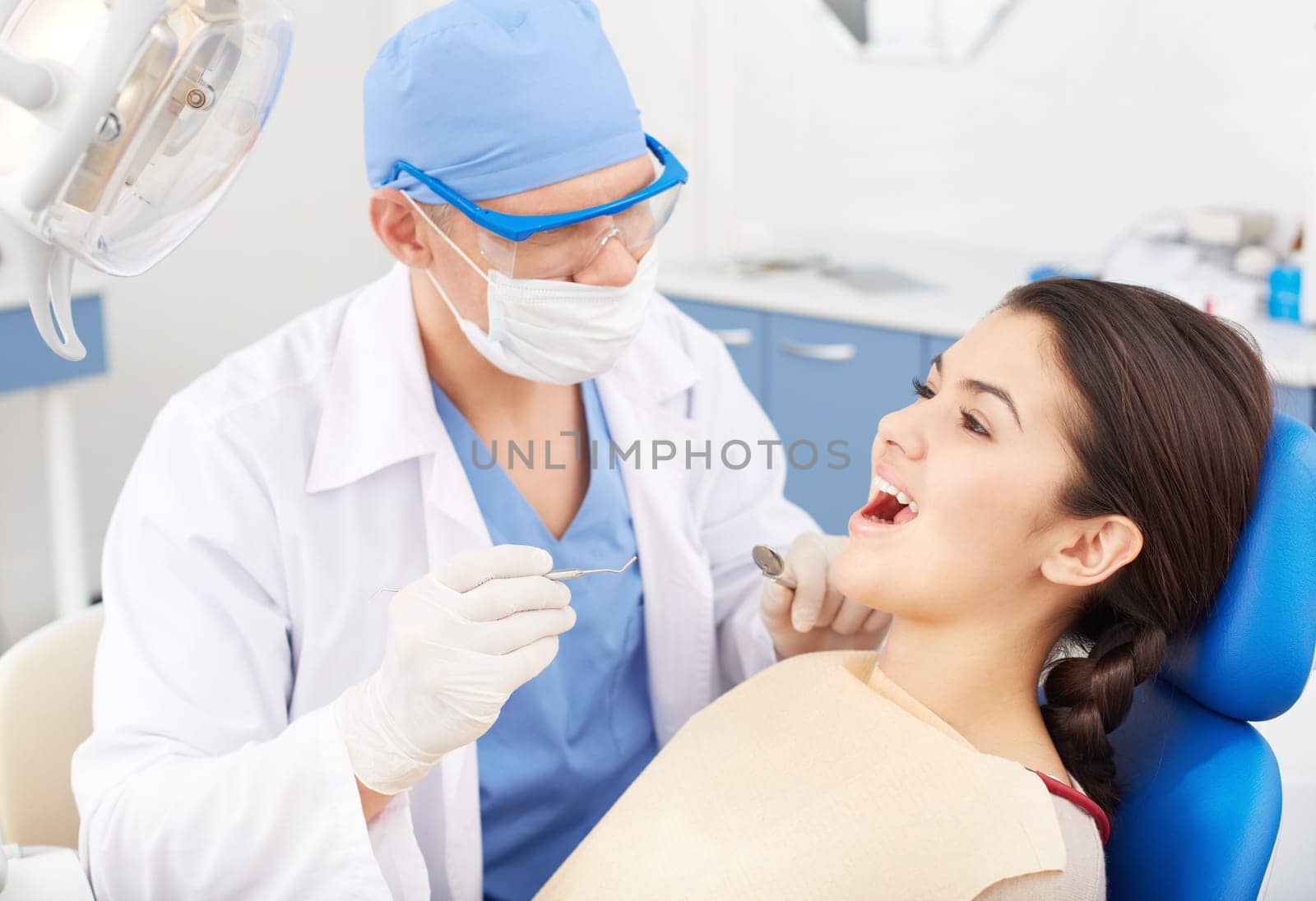 Young girl with open mouth before oral checkup at the dentist’s