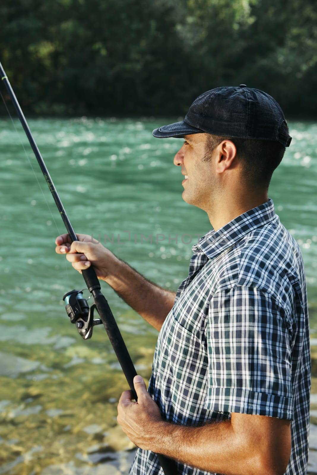 mid adult man on holidays on river, relaxing and fishing trout