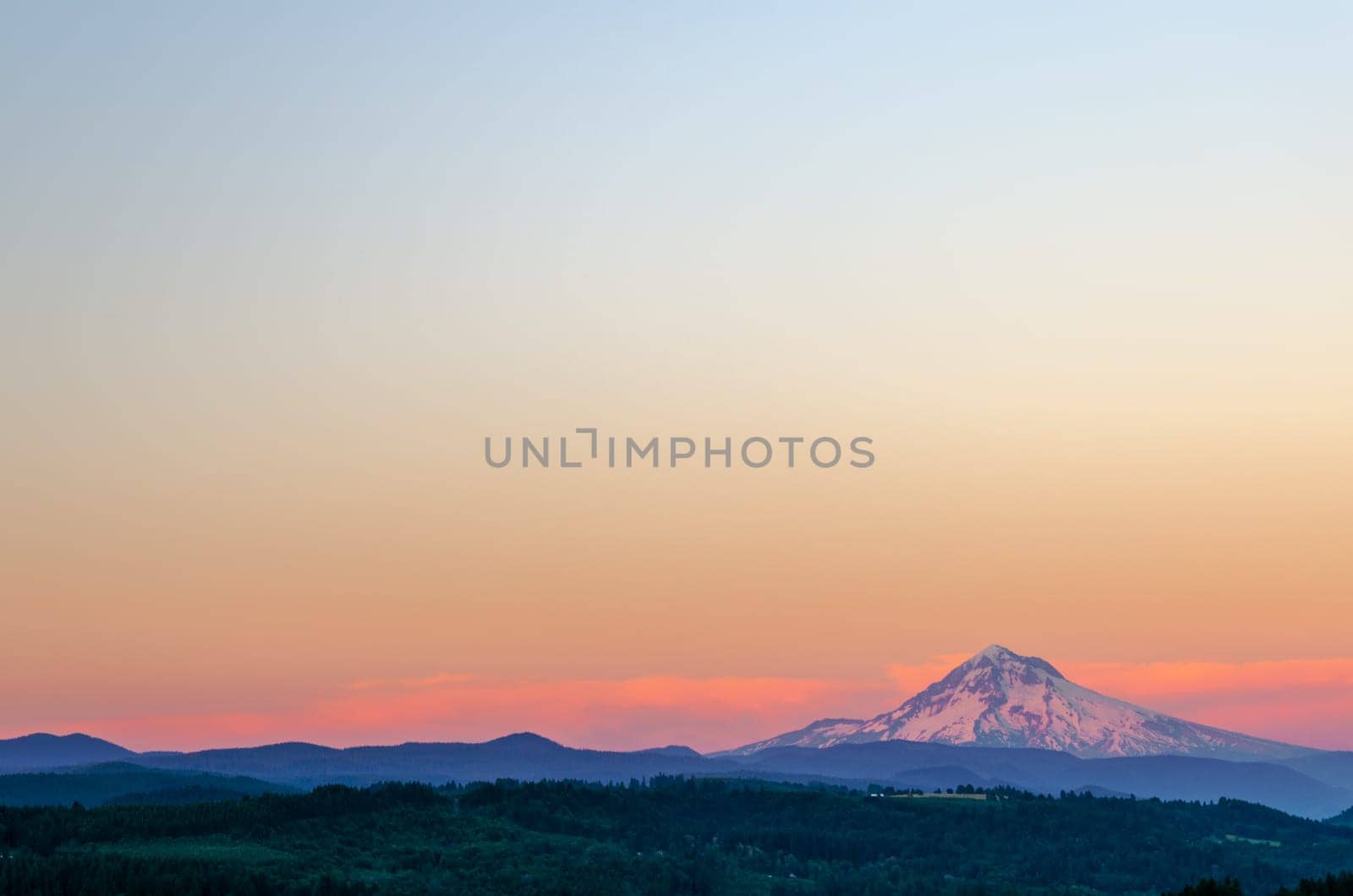 Mount Hood looking purple at sunset with sky taking up most of the frame