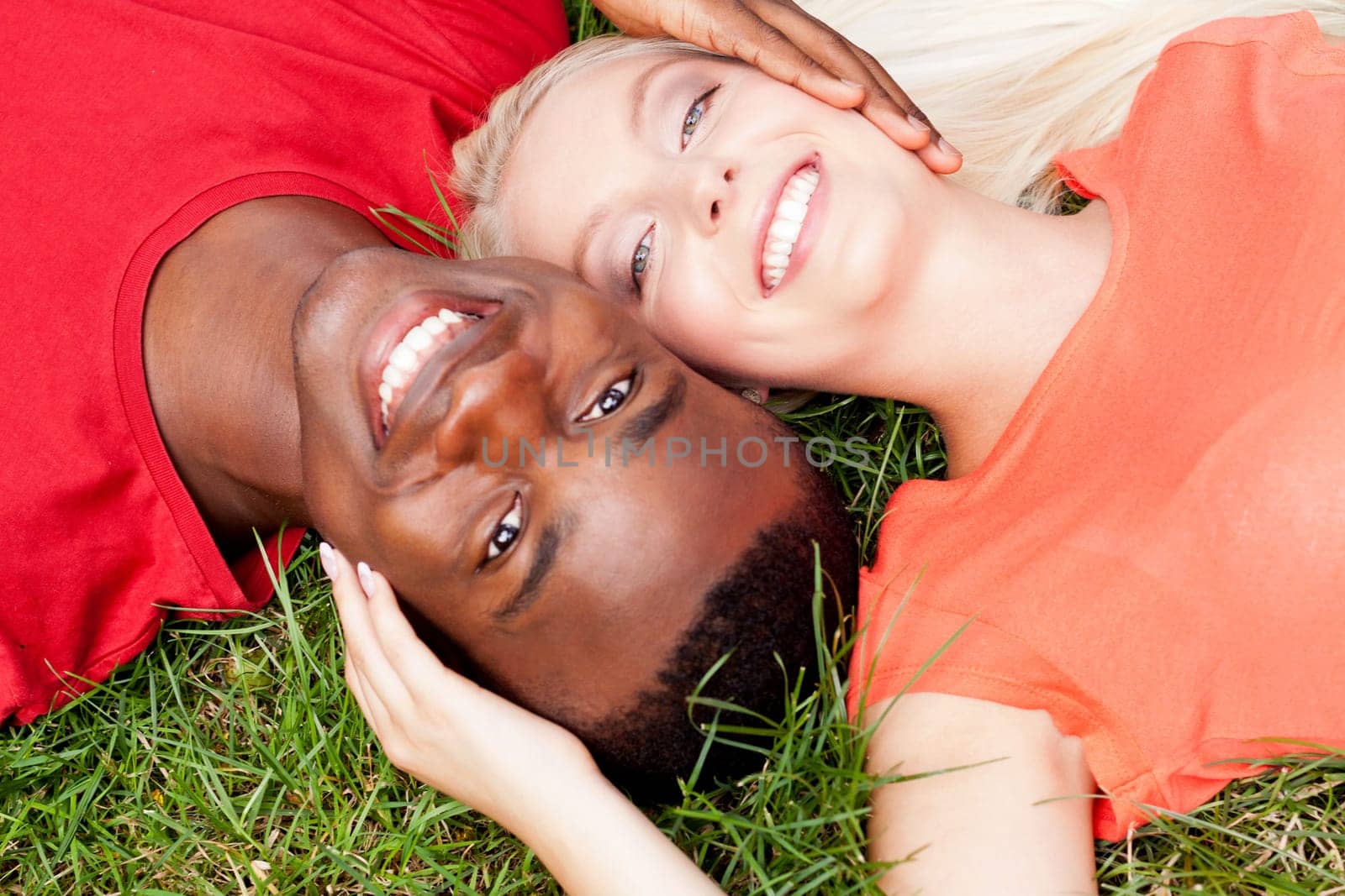 Young in love multicultural couple on a meadow in summer leisure fun