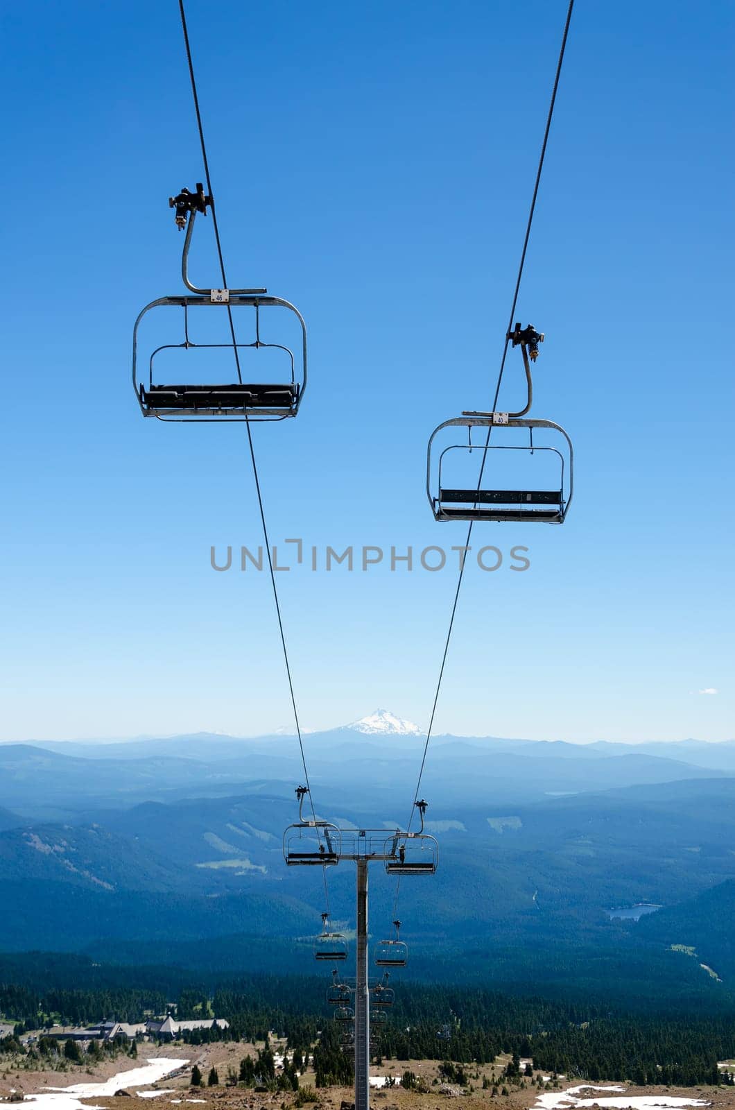 Chairlift running down Mount Hood with Mount Jefferson visible in the background